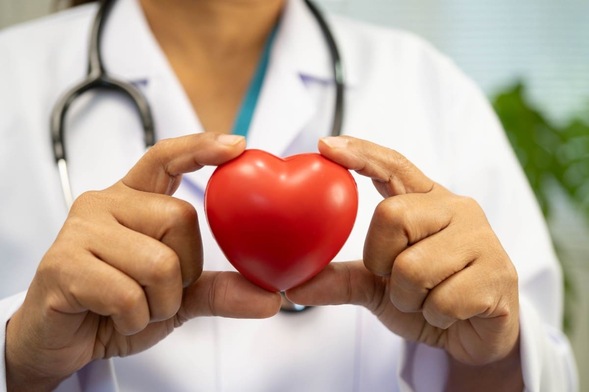 Doctor holding red heart-shaped object.