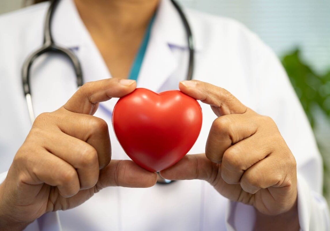 Doctor holding red heart-shaped object.